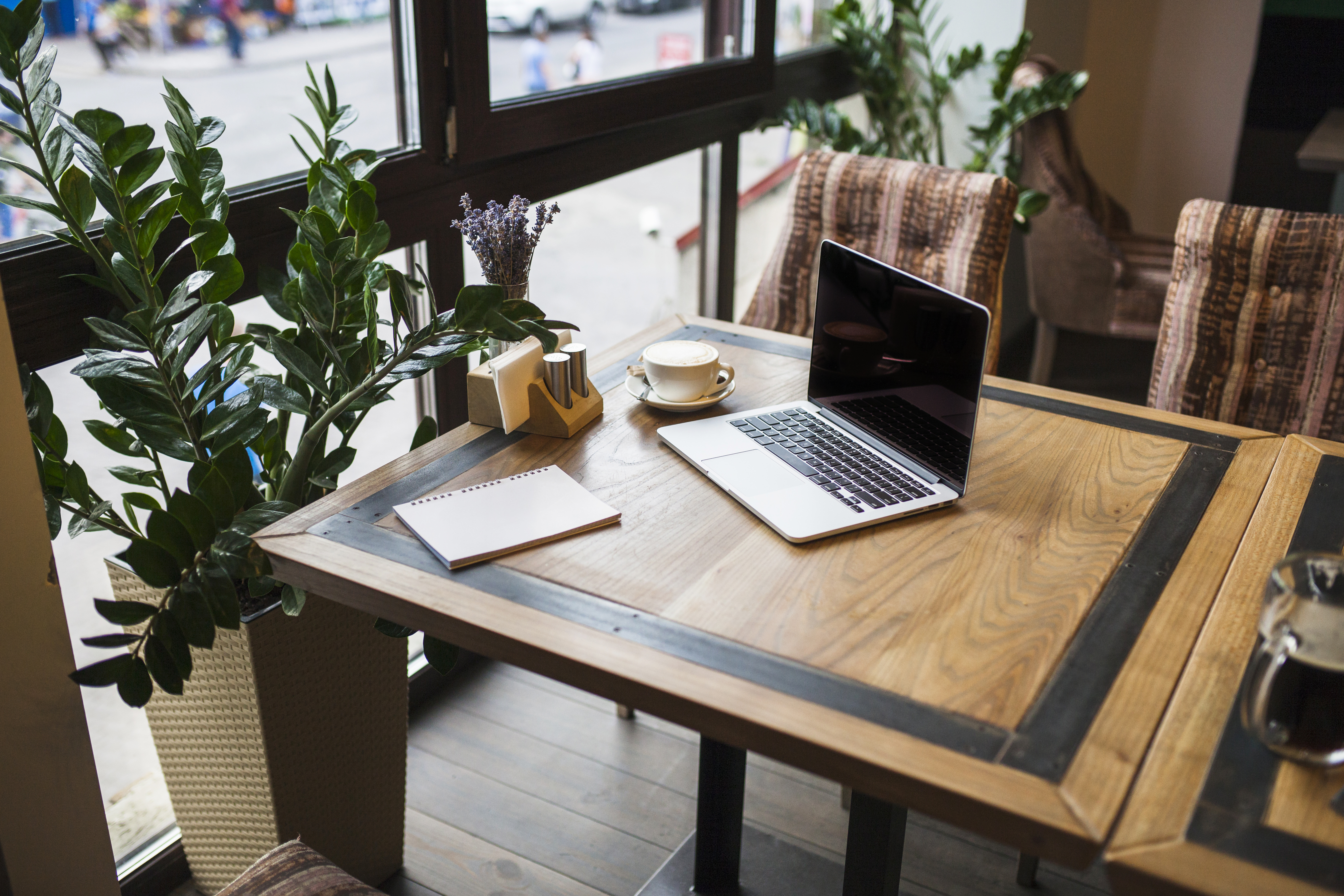 laptop-with-notepad-cafe-table